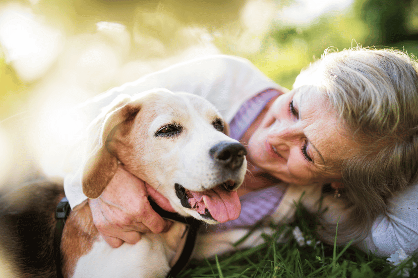 Senior woman with a senior dog in a garden