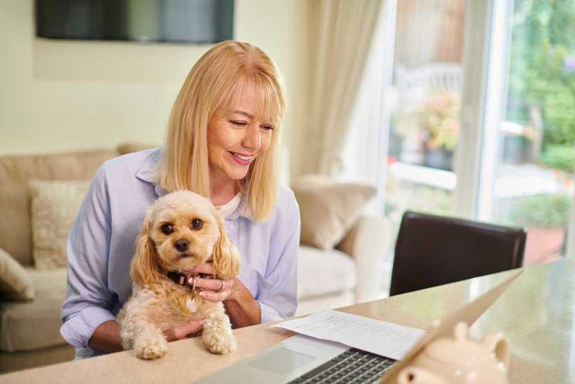 woman with dog reviewing senior dog insurance online